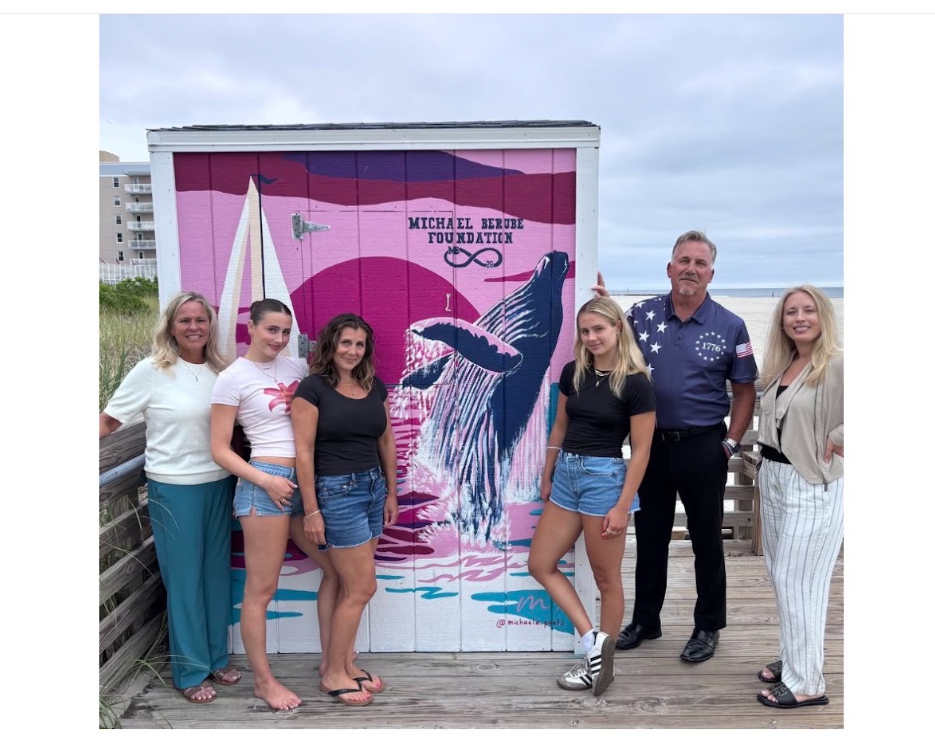 Group standing in front of a colorful whale mural painted for the Michael Berube Foundation